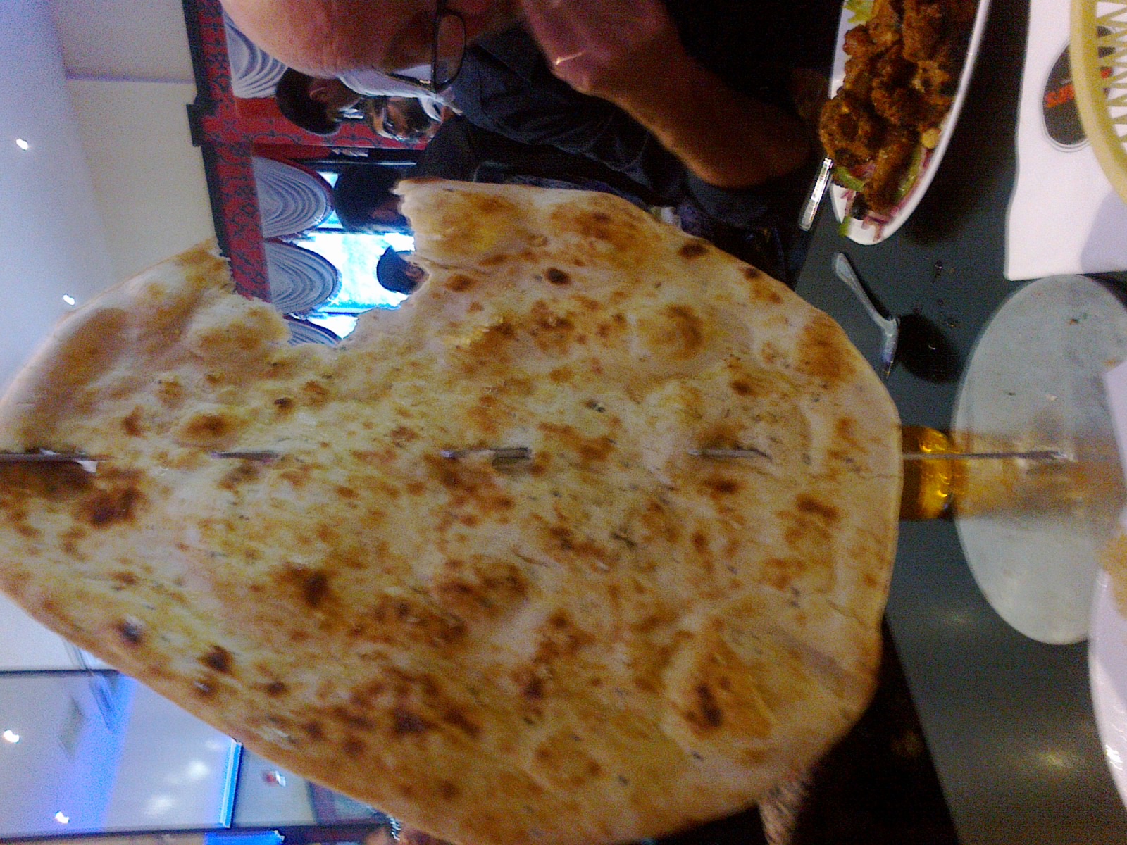 a person holding up food that looks like a giant piece of bread