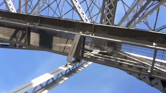a view from the bottom of the tower with the side of the metal structure, which is attached by wire