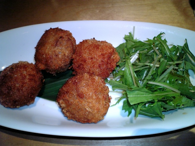 fried meat patties and green vegetables on a white plate