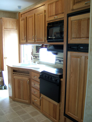 a kitchen with a refrigerator, stove and cabinets
