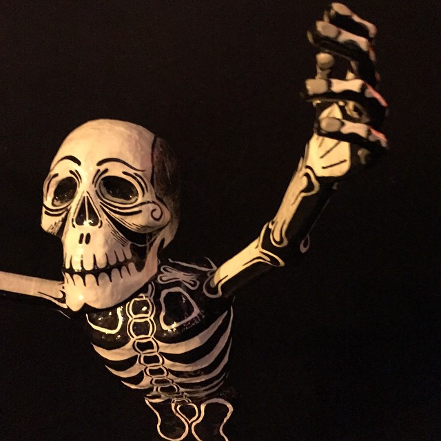 a white skeleton waving his hands up in the air