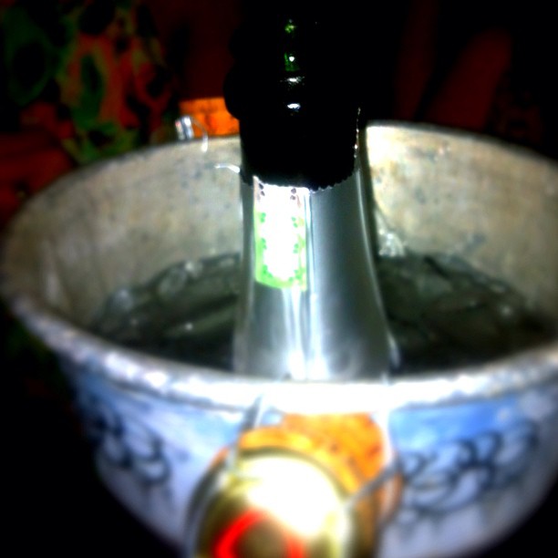 a glass bottle sitting in top of an ornate bowl