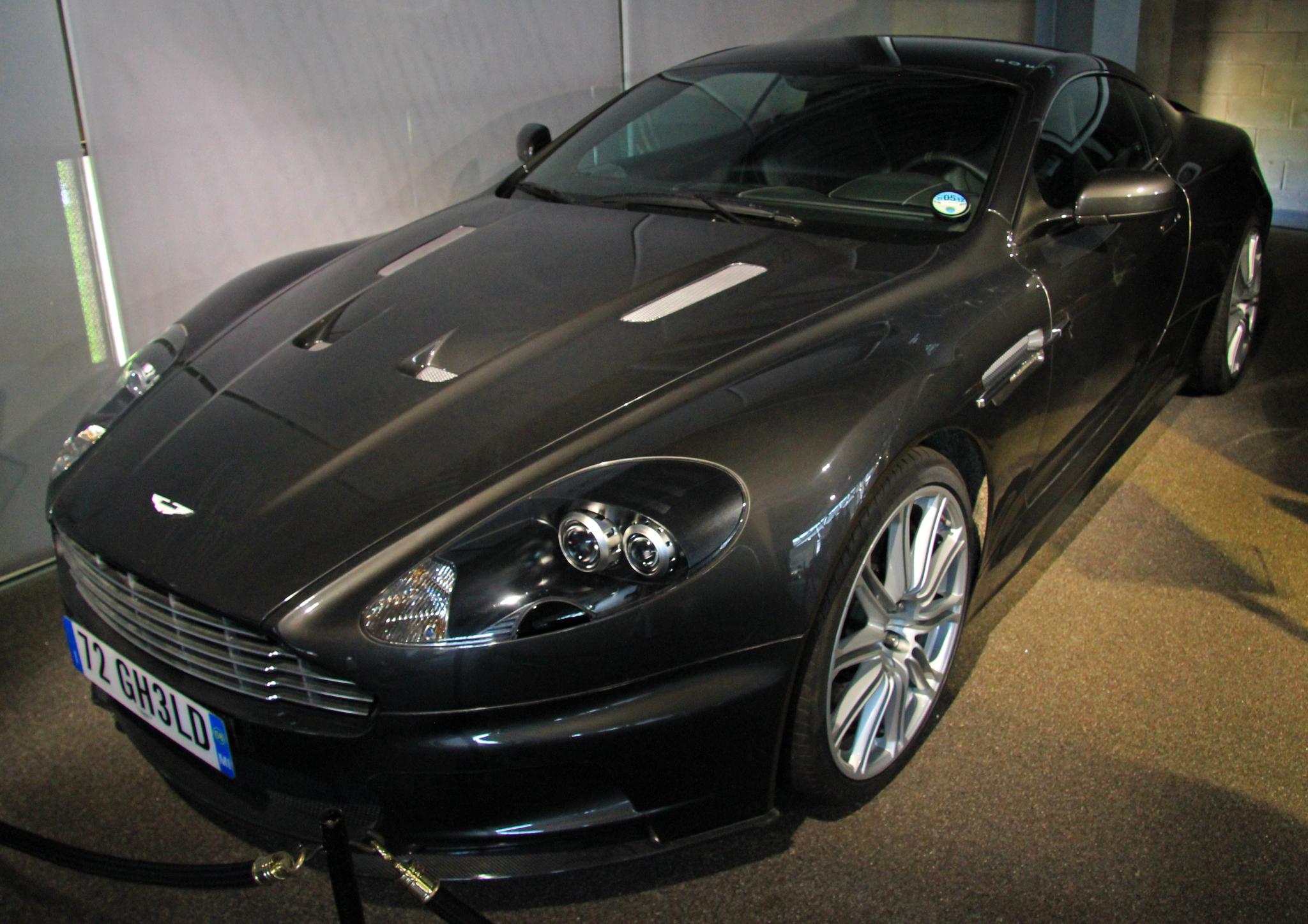 a black car with a silver stripe is parked in a garage