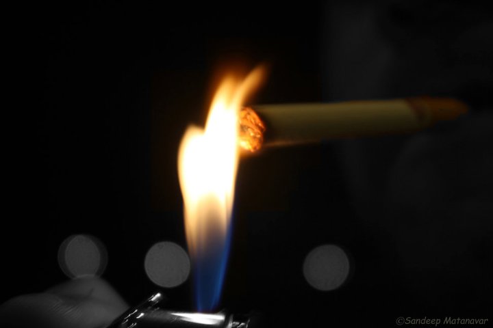 a cigarette burning next to a lit match