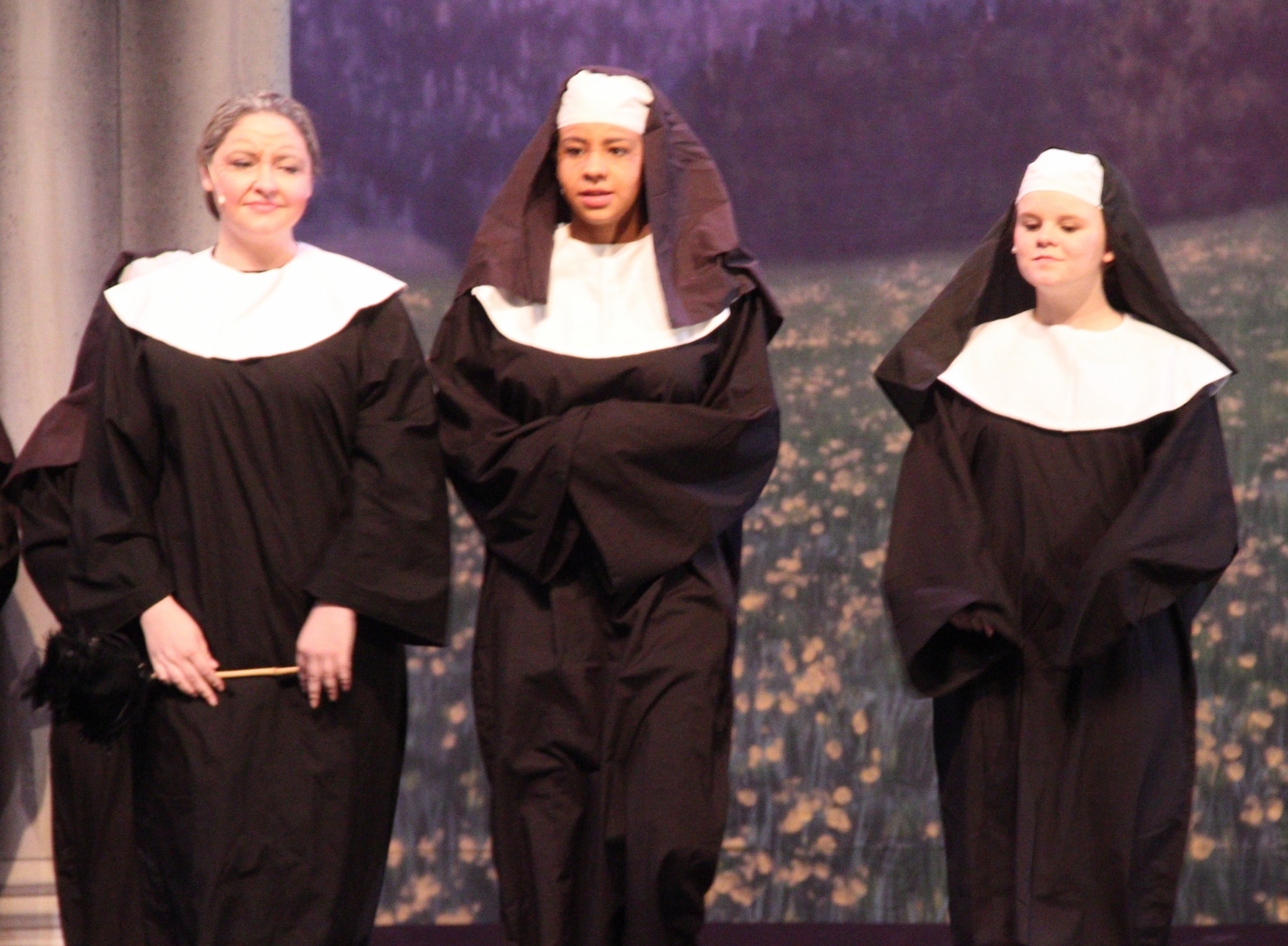 three women wearing nun outfits standing side by side