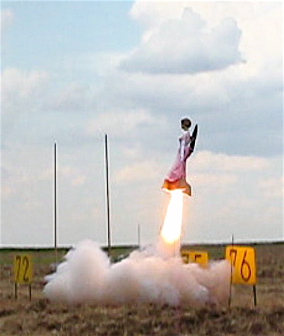 a man in a long pink dress is in the air launching a rocketset