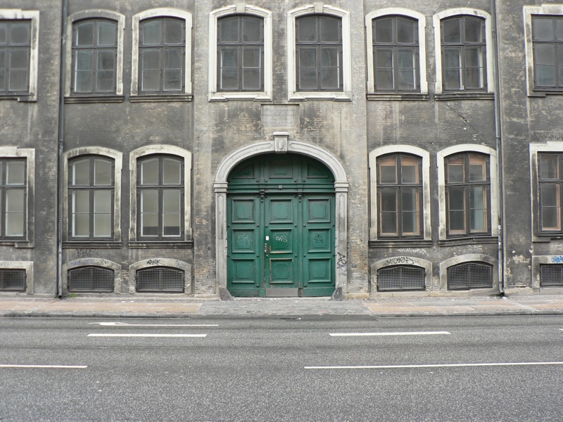 an old style building with multiple windows and a green door