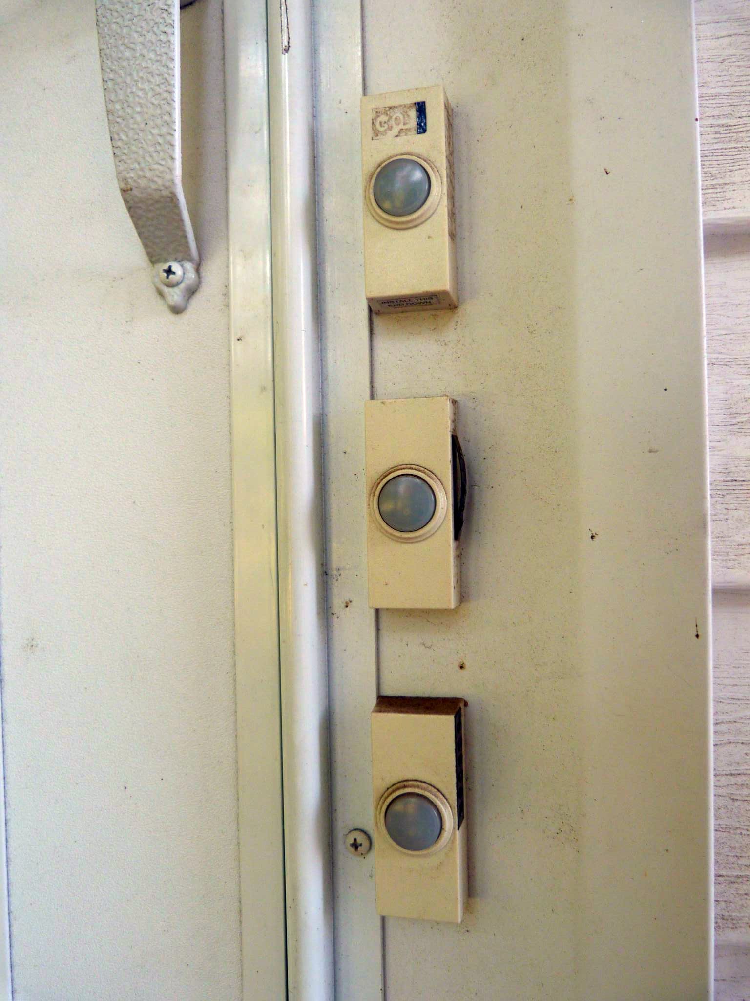 three switches and a white latch are on a door