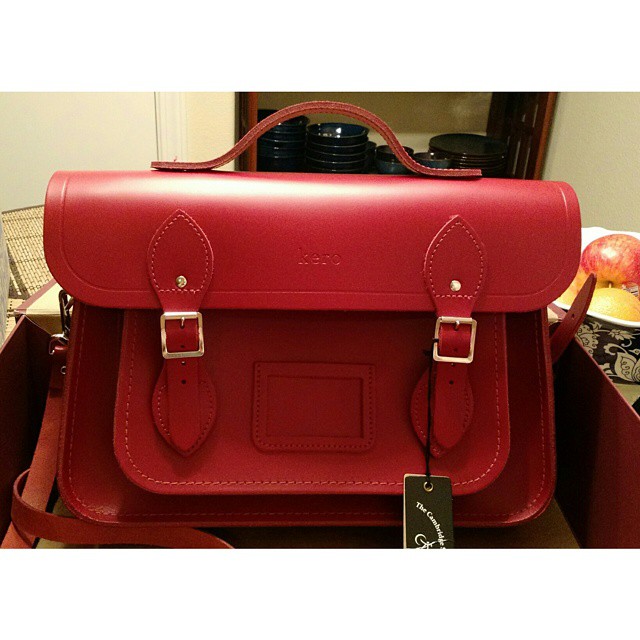 a red leather briefcase sitting on top of a wooden table