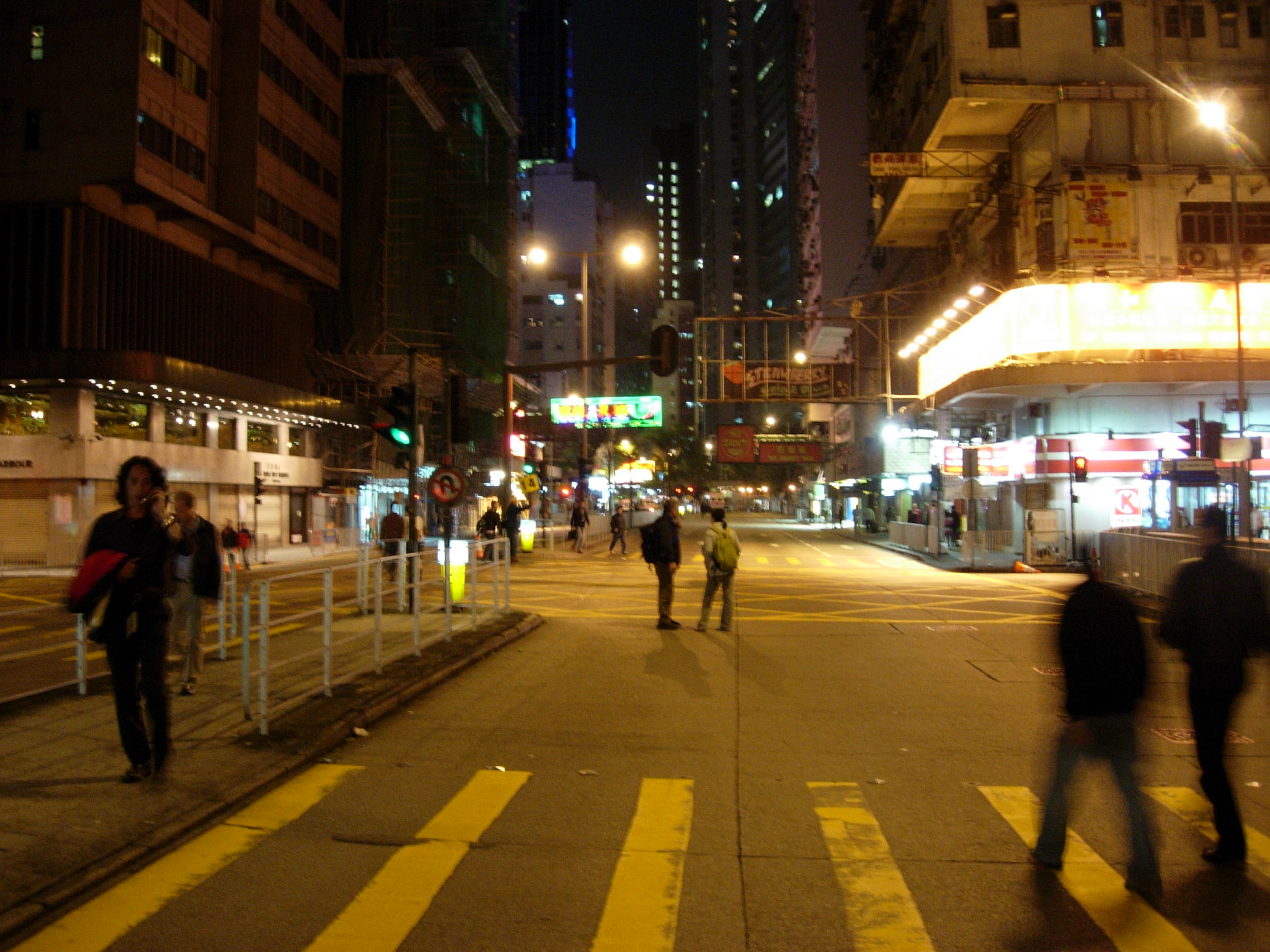 several people walking down the street by the curb