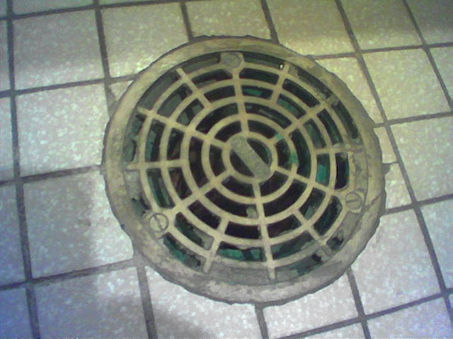 the drain hole has green, black, and blue glass in it