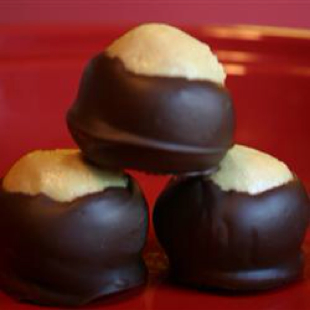 five pieces of chocolate with white chocolate and peanut er in the middle