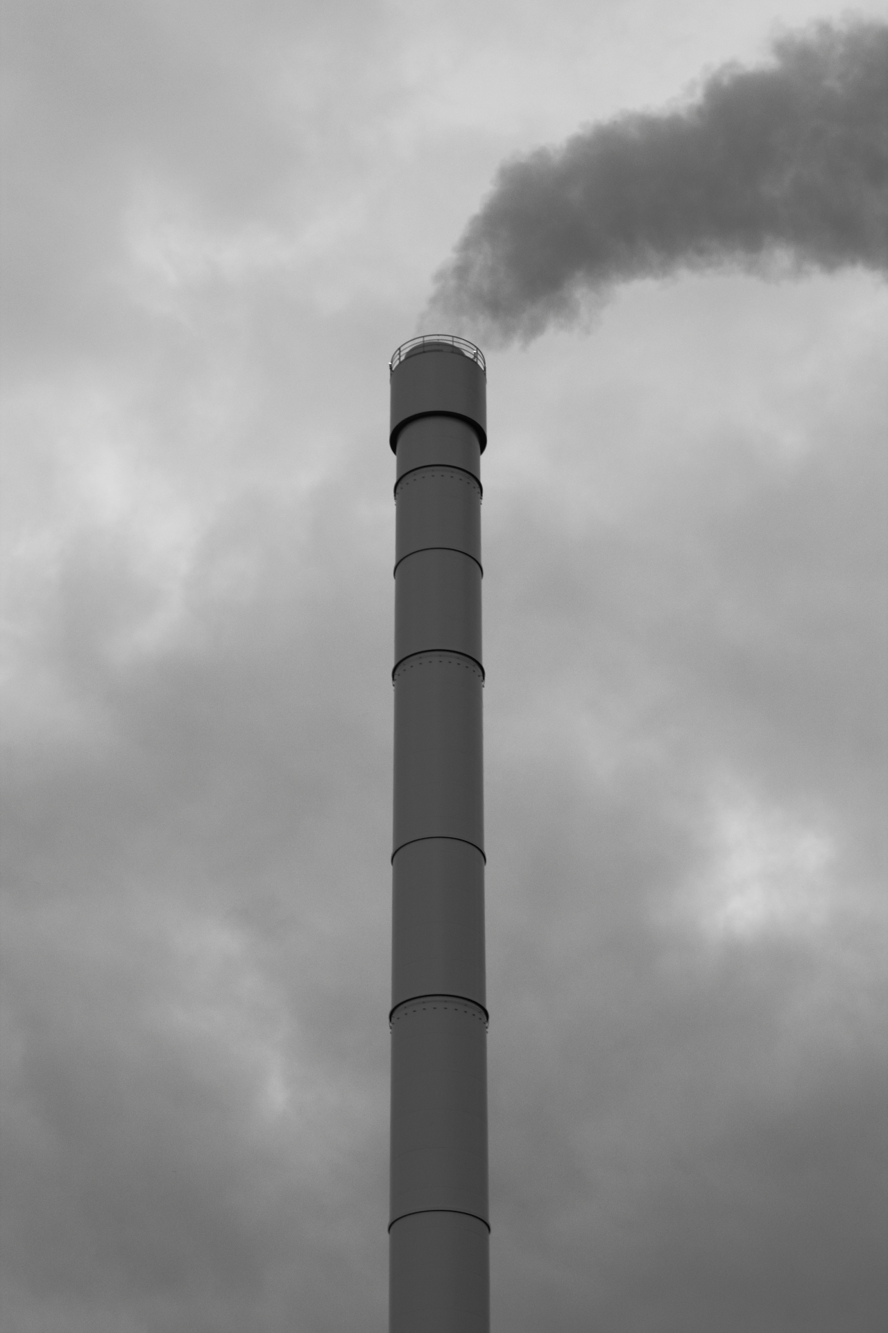 smoke billows from a smoke stack on top of a building