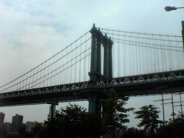 a view of the large bridge as it passes under the buildings