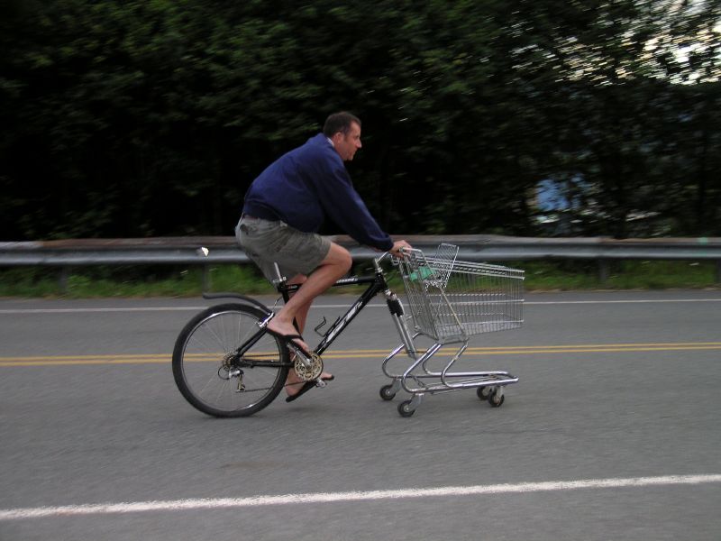 a man hing a shopping cart down a street