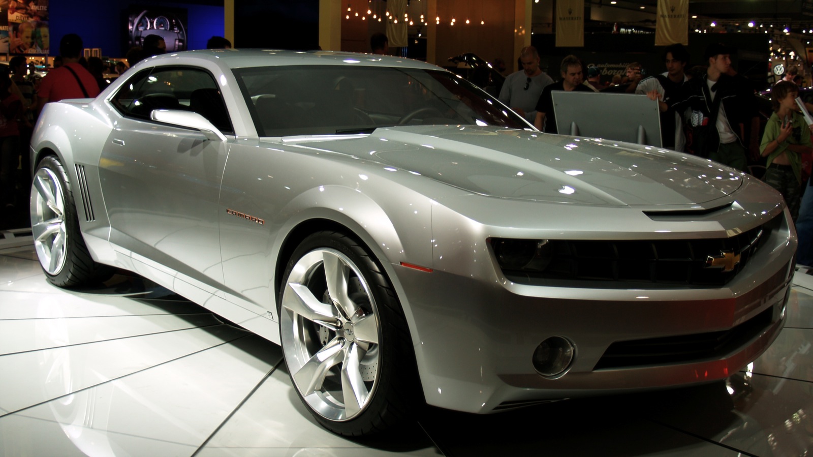 there is a silver chevrolet camaro on display at this event