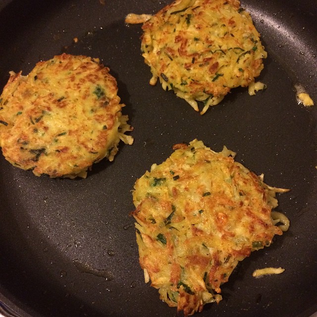three food patties in a frying pan on a stove