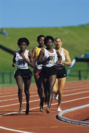 four girls on a track run while holding hands