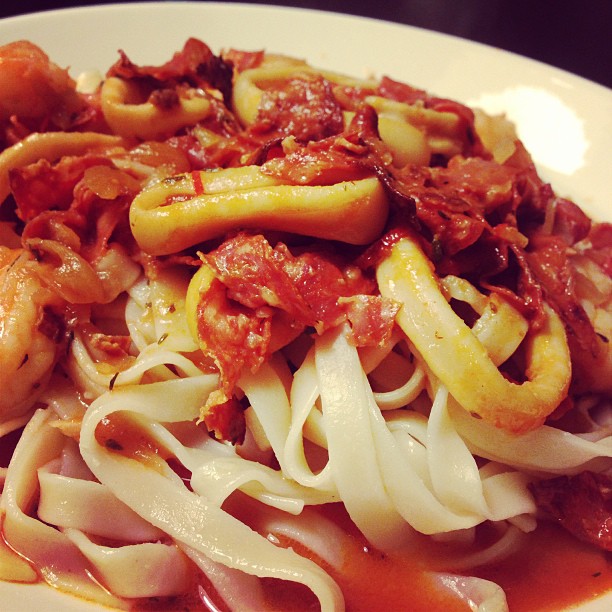 pasta with tomato sauce and shrimp, served on a white plate