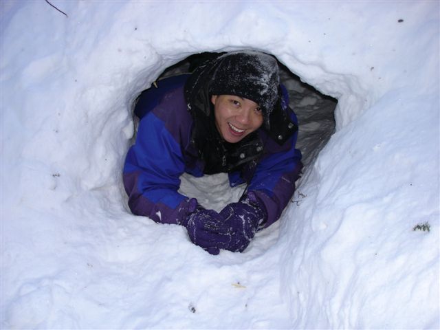 a young man is buried in snow in a hole