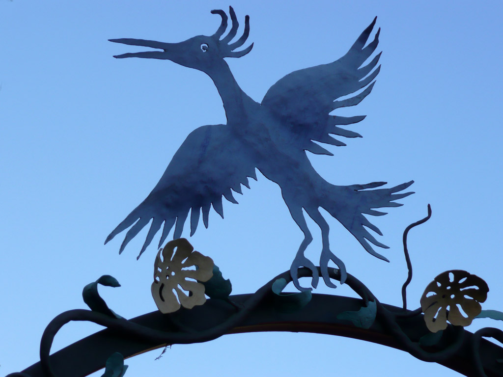 a decorative bird on top of a tree nch