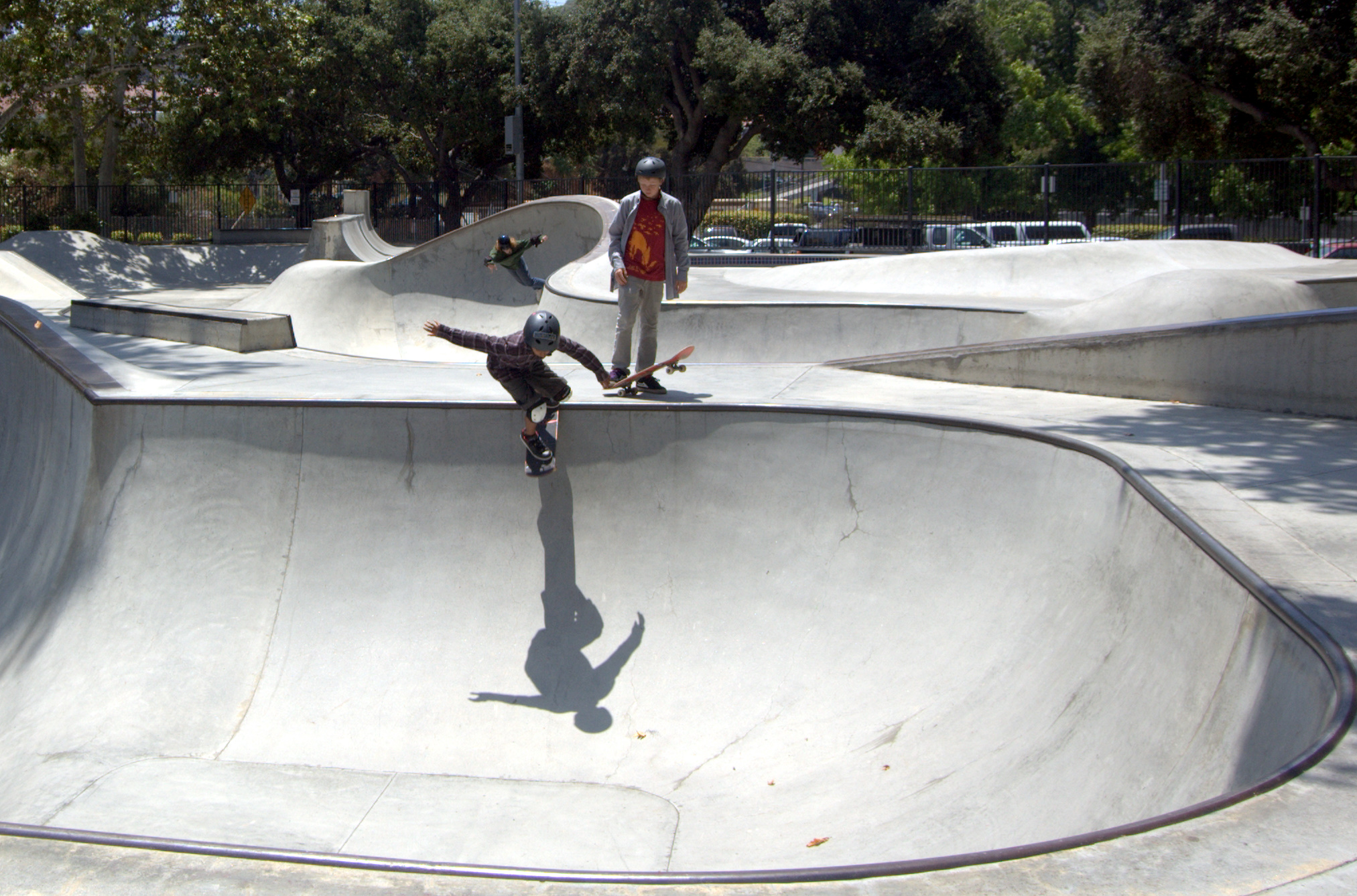 two boys skate boarding at a skateboard park