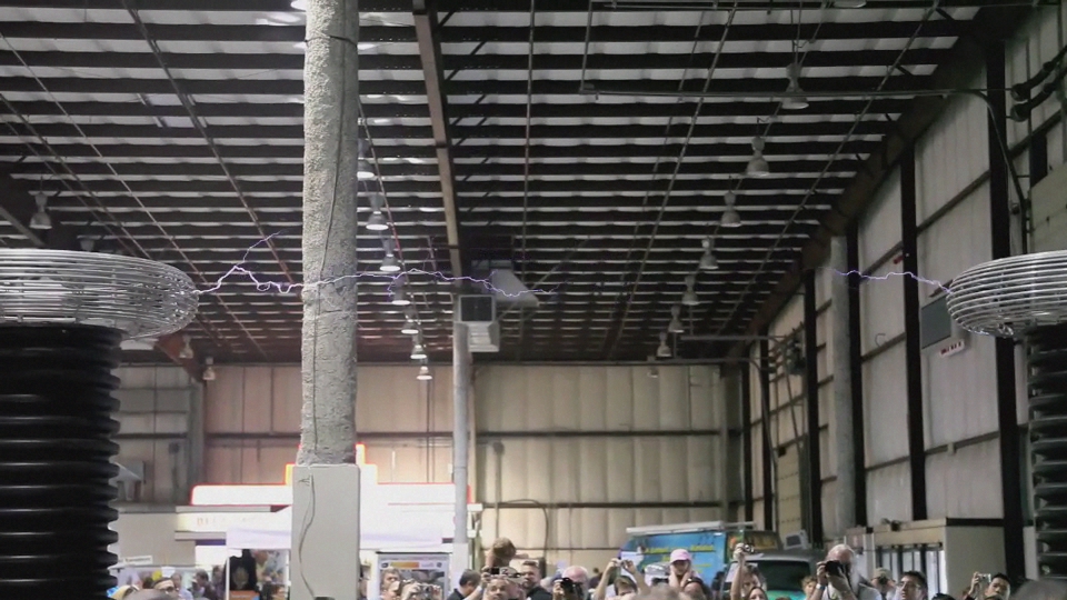 a huge number of people standing in a warehouse