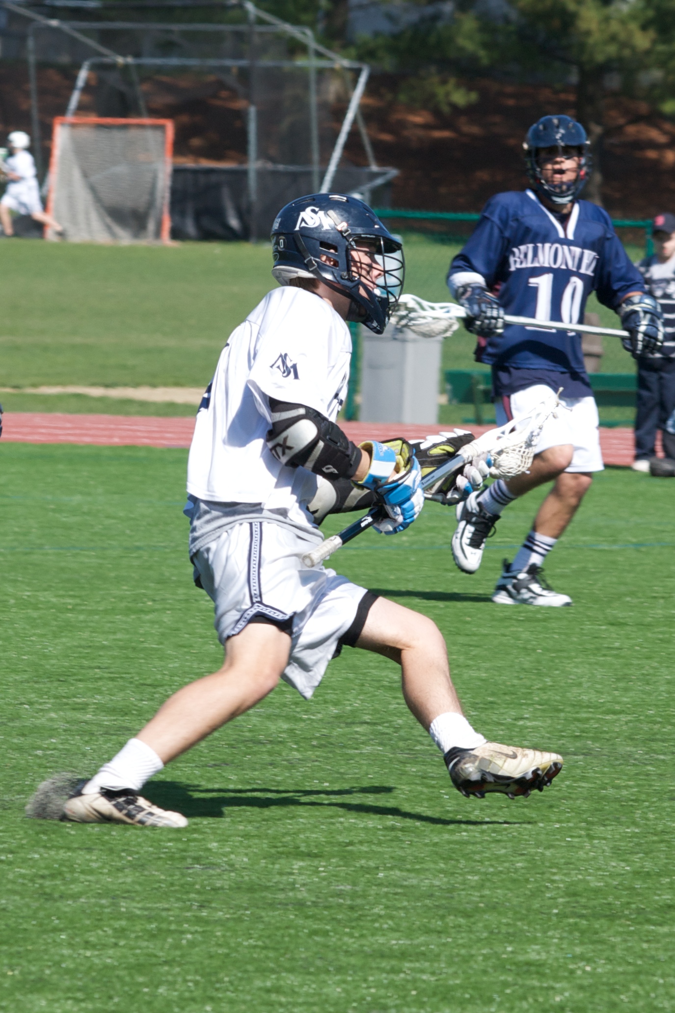 a boy running with a lacrosse ball wearing gloves