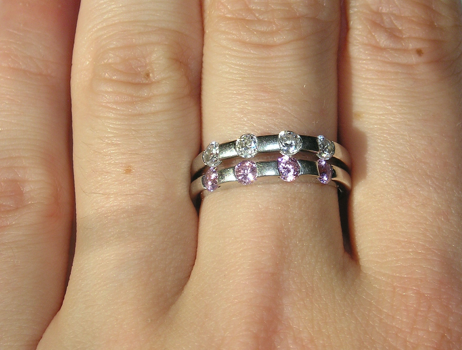 a ring with pink and white diamonds on it