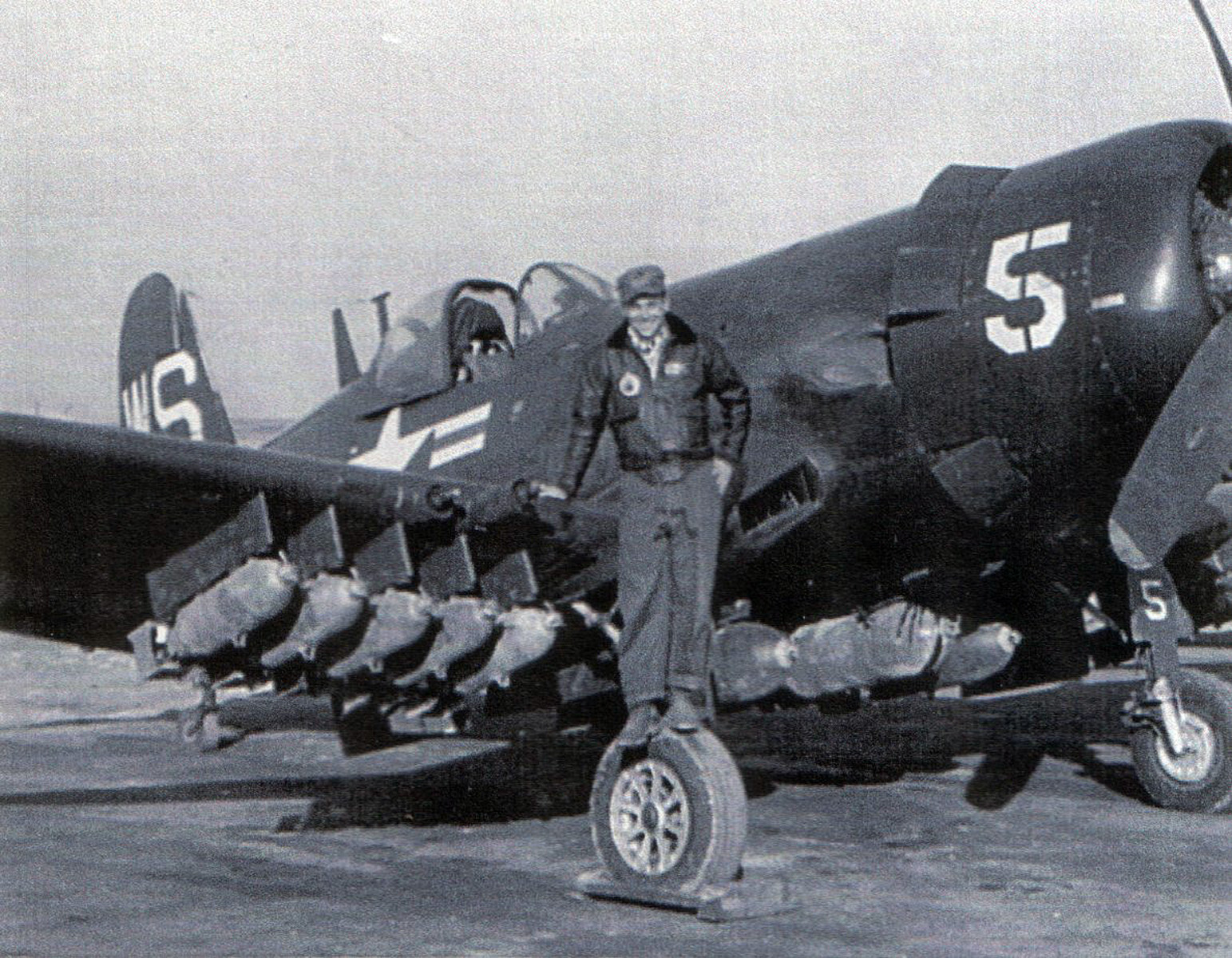 an old po of two soldiers standing in front of an airplane