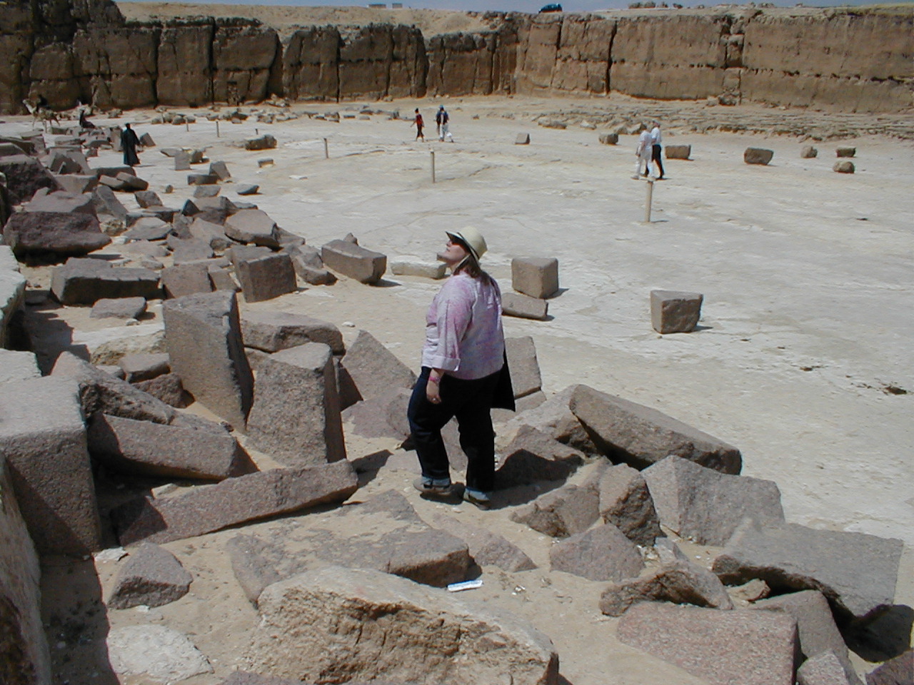 a woman stands on rocks in the middle of an open area