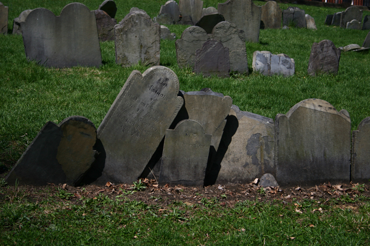 a graveyard in a field of grass surrounded by tombstones