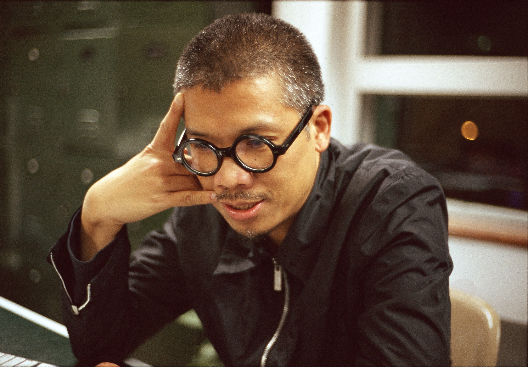 a man wearing glasses looking at a laptop