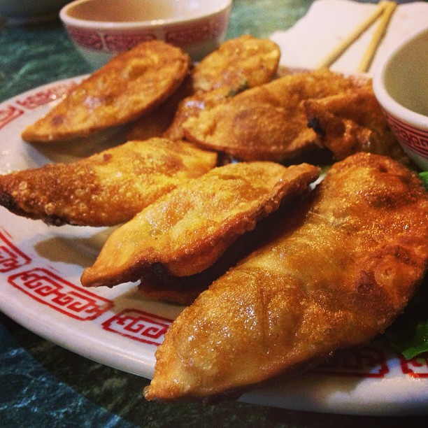 some chinese fried food on a plate with chopsticks