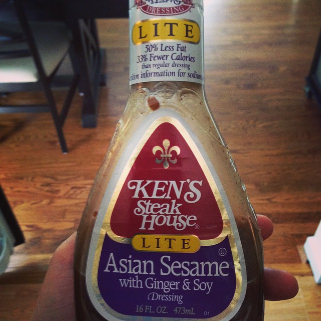 someone holding a bottle of asian sesame dressing