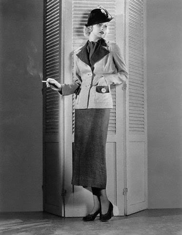 a woman standing near a door with a cigarette
