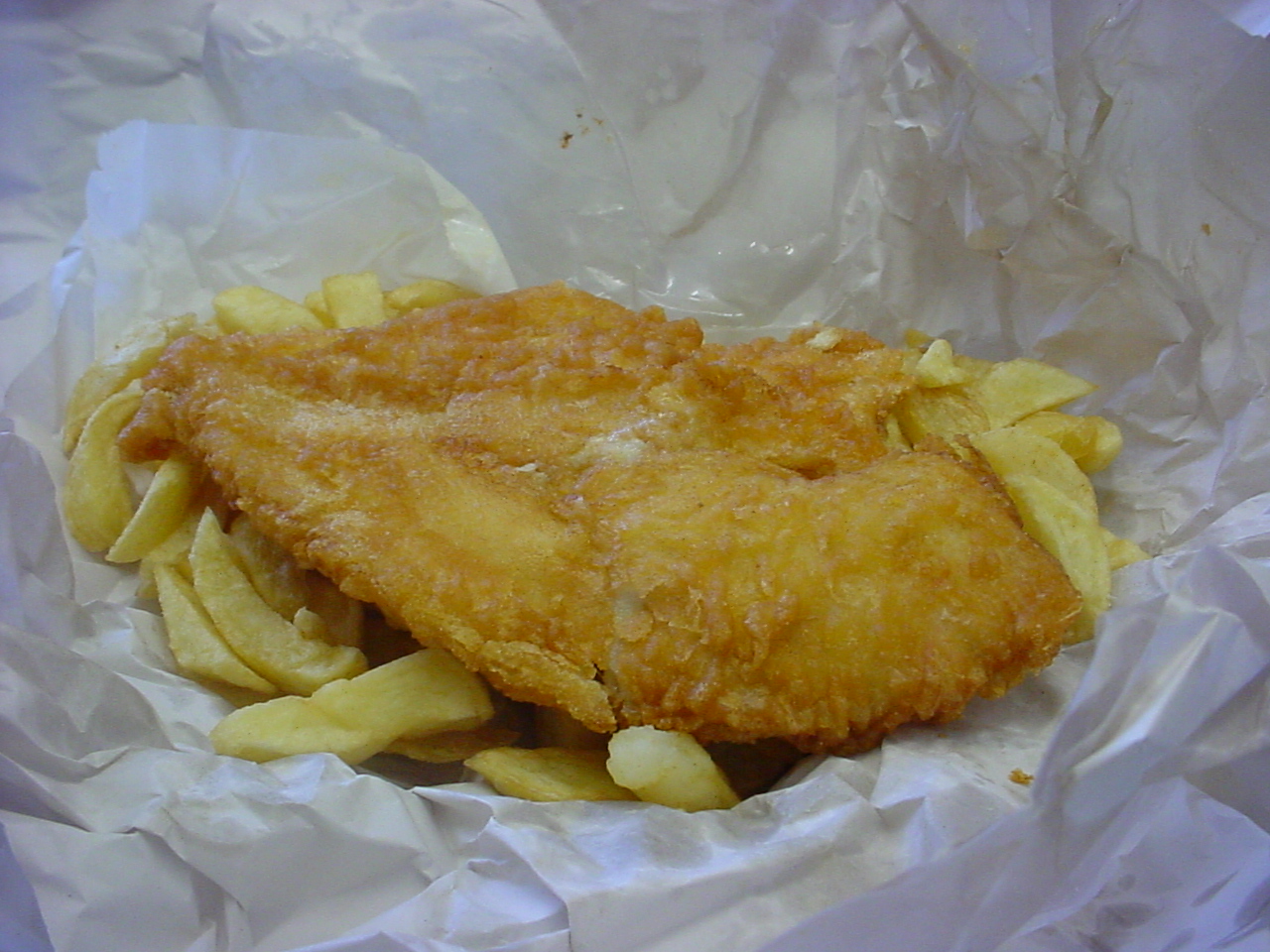 fish and chips are in paper wrapping