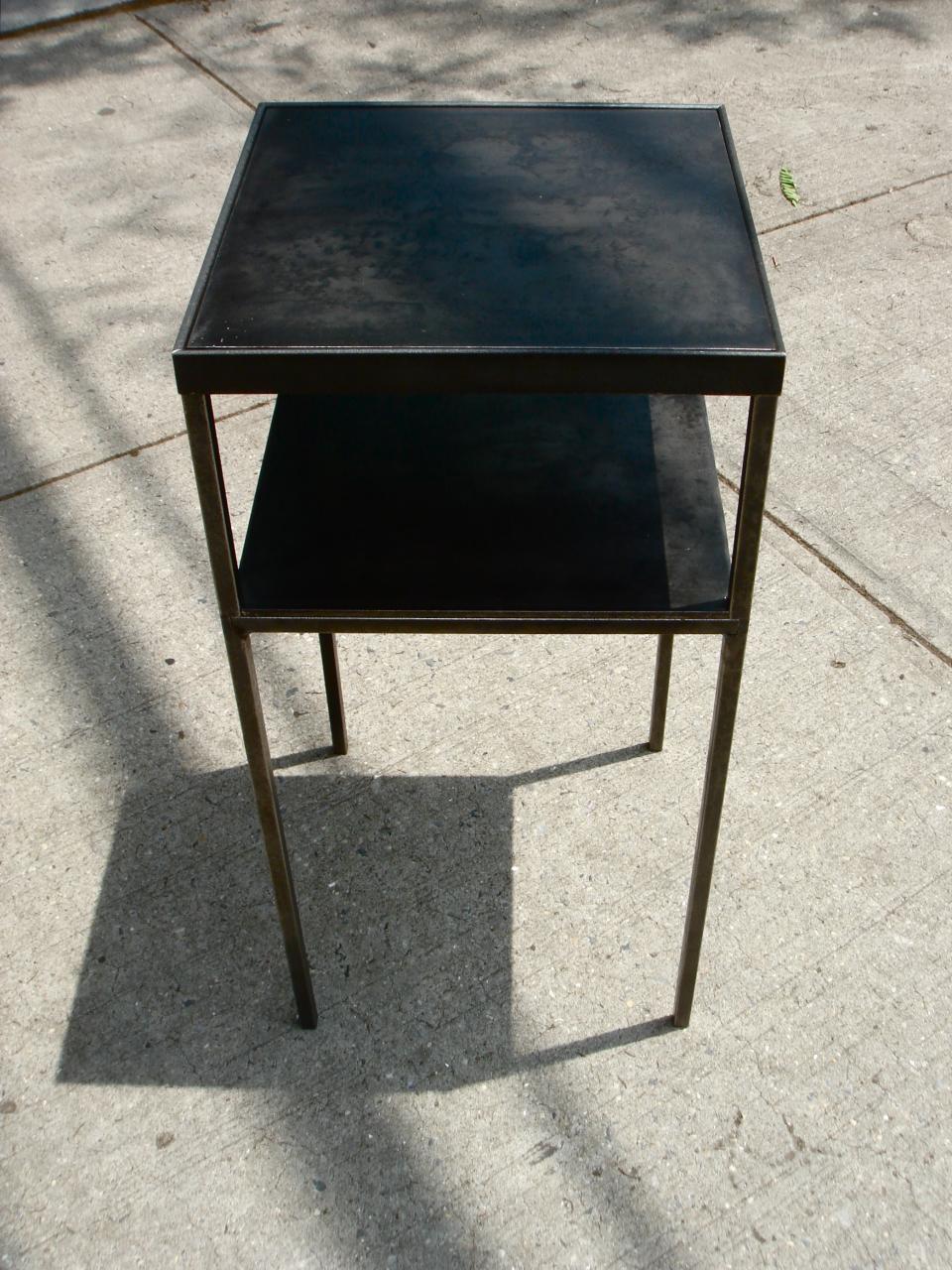 black end table with one drawer on top on the sidewalk