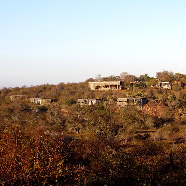 a small group of huts are sitting on the side of a hill