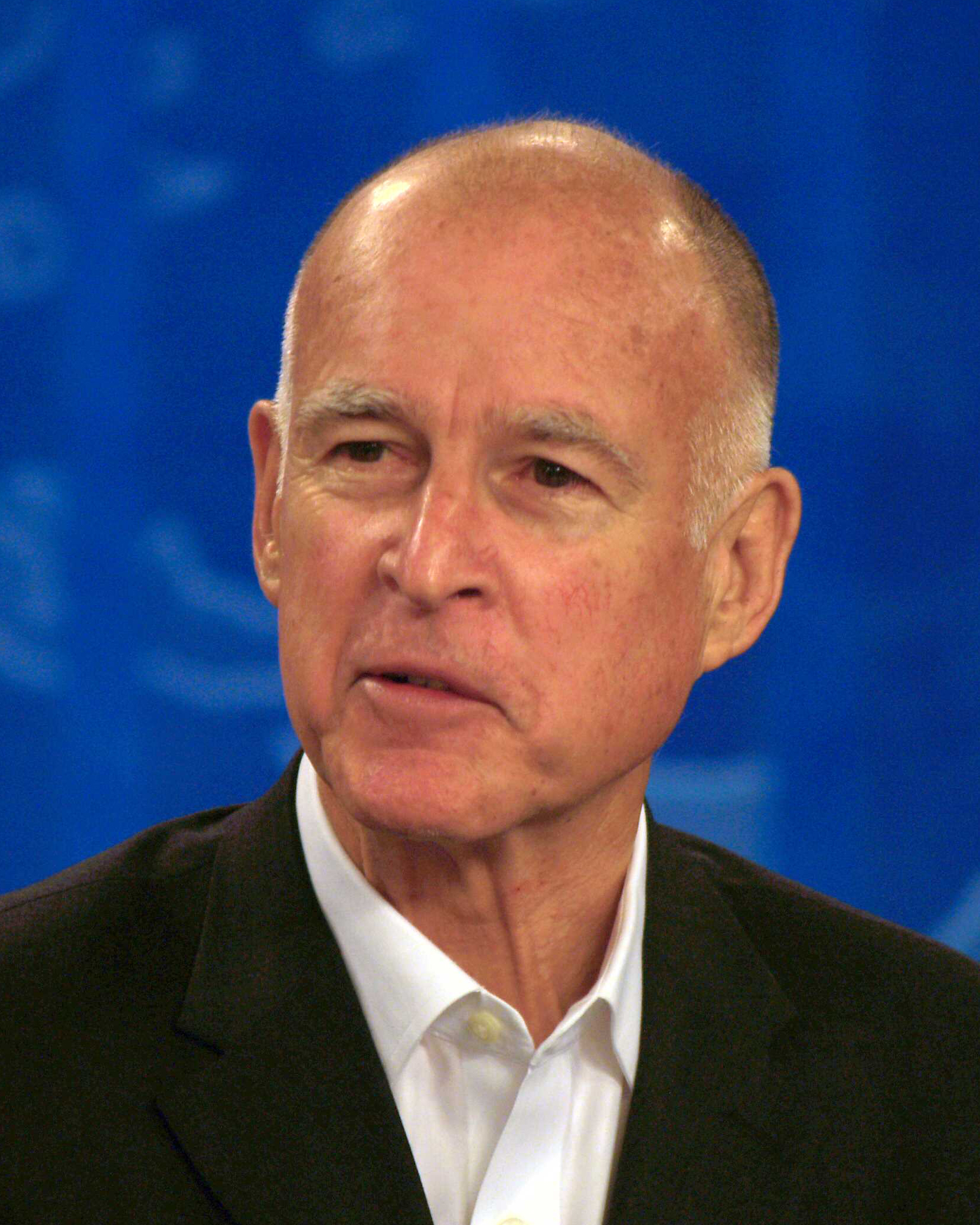 a bald man wearing a black suit and white shirt