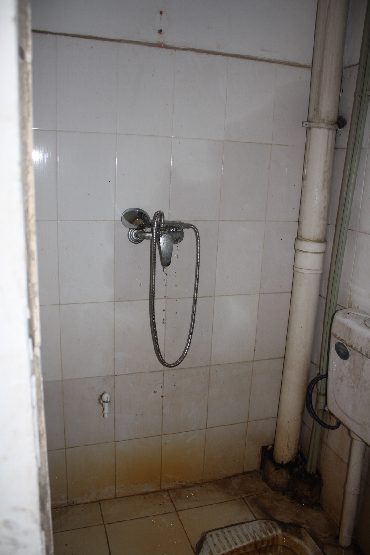 a filthy bathroom is shown with dirty walls