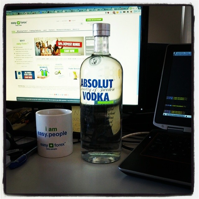 a bottle of vodka sitting next to a computer