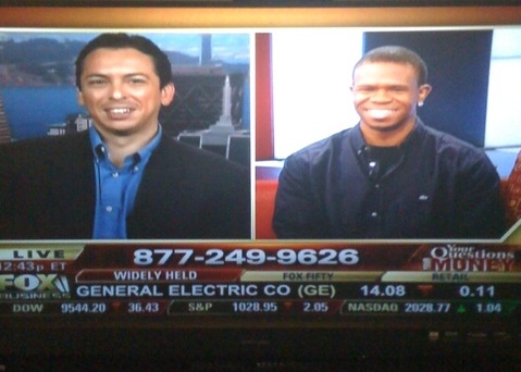 two men are smiling on television together