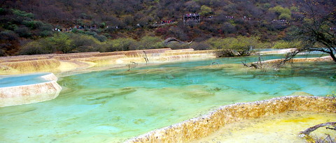 the water is bright yellow and green near a valley