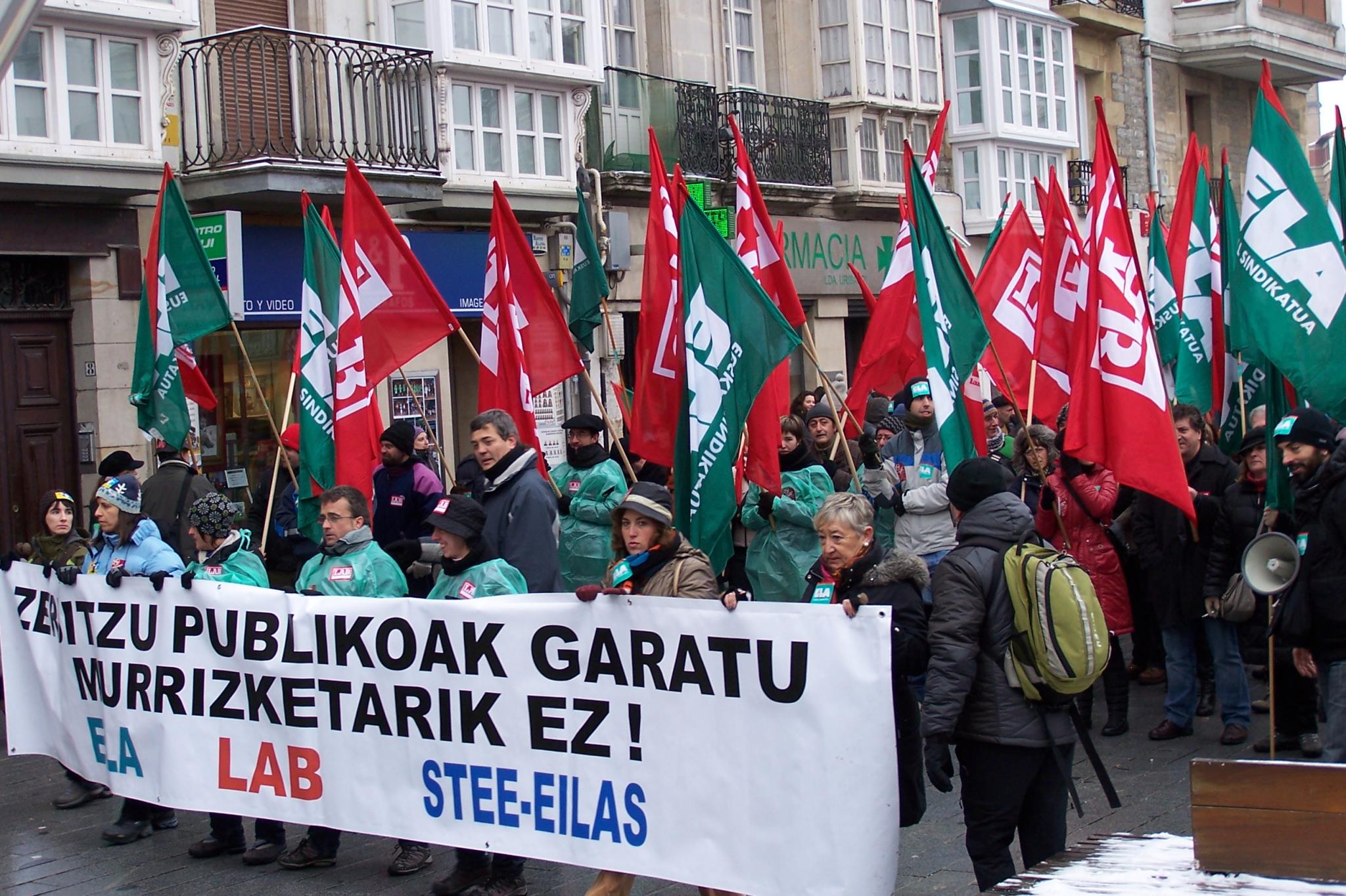 a group of people holding banners and walking in a street