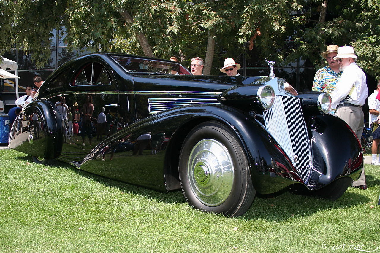 a black car parked on a green grass covered field