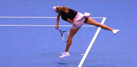 a woman swings at the ball with her tennis racket