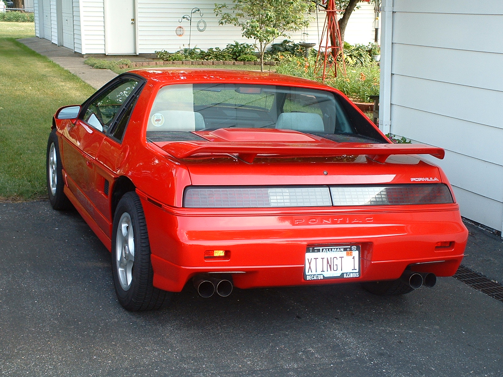 the red sports car is parked in the driveway