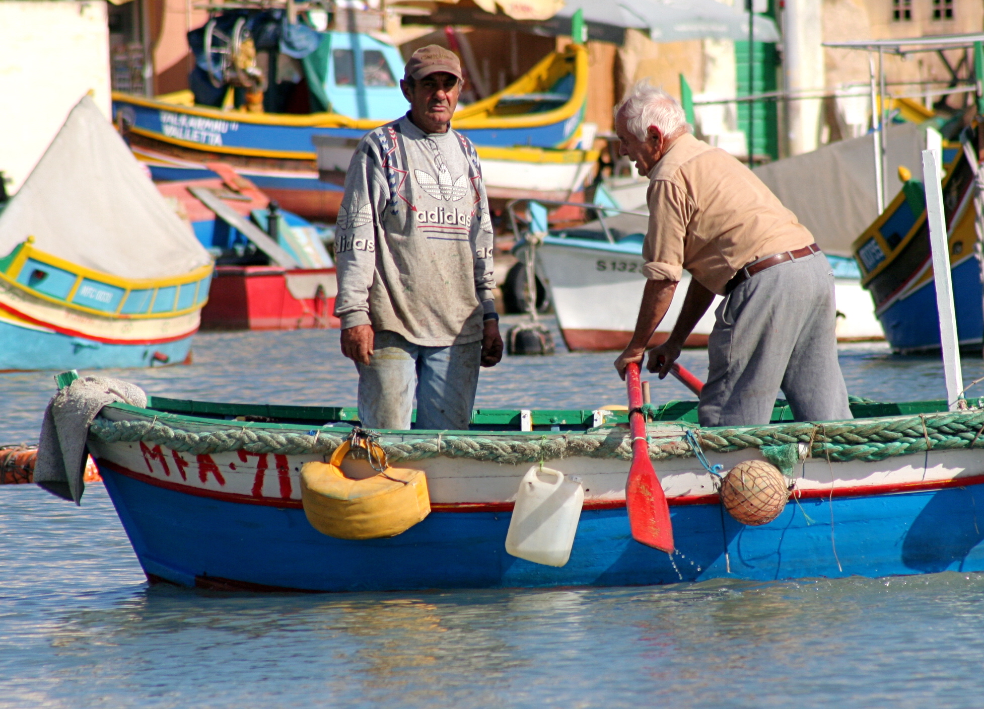 two men with oars on a small boat in the water