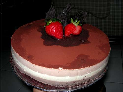 a chocolate cake with two strawberries on top